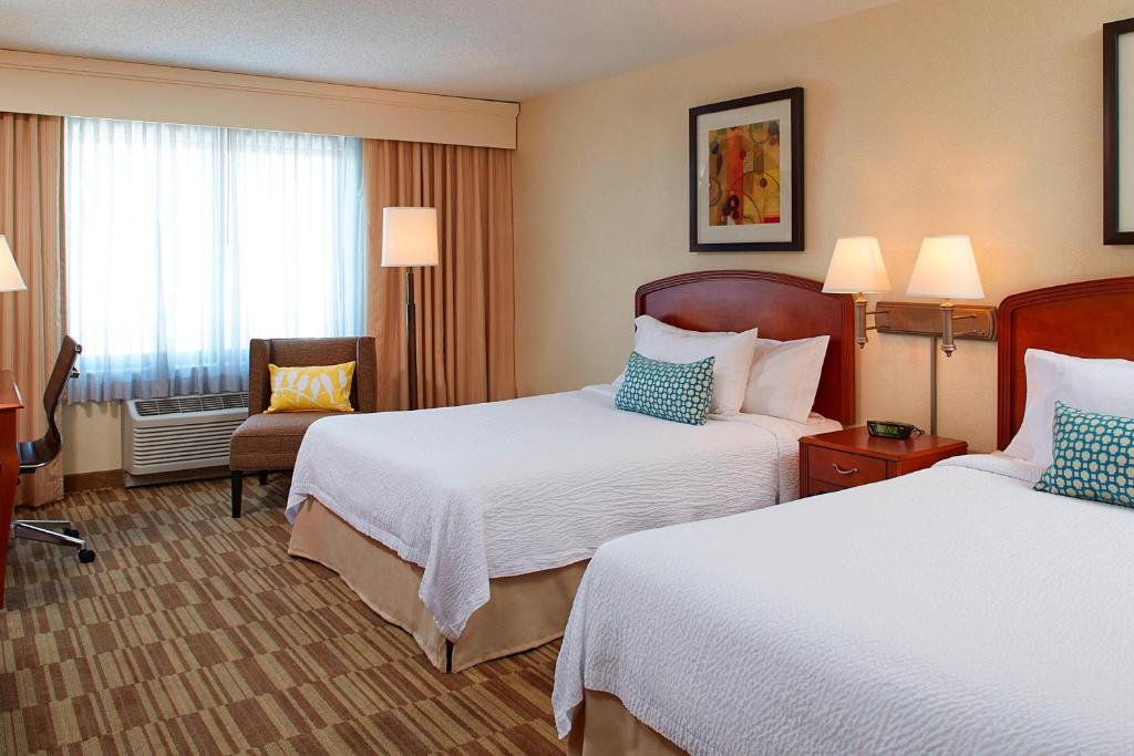 um quarto de hotel com duas camas e uma cadeira em Courtyard Denver South Park Meadows Mall em Centennial