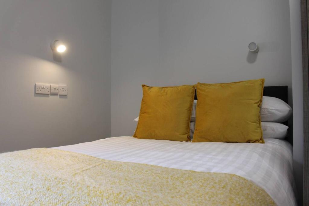 a bedroom with a bed with yellow pillows at The Arches The Wee Yin in Stirling