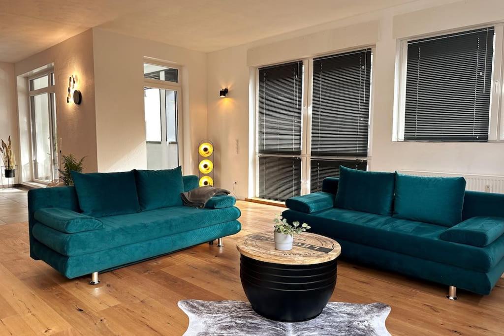 a living room with two blue couches and a table at cameiroo - Apartment Euskirchen in Euskirchen