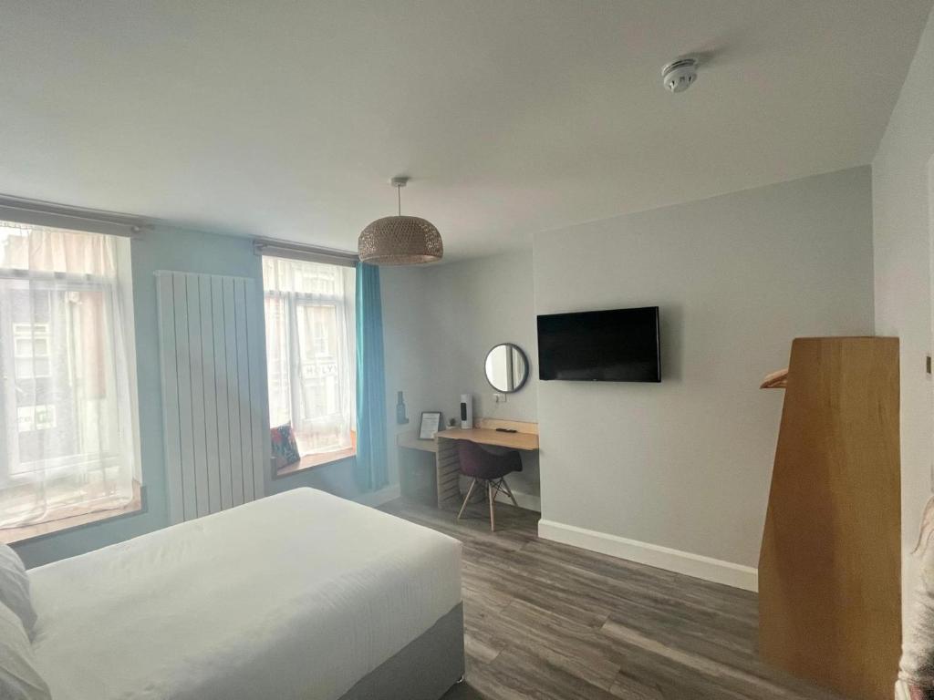 - une chambre avec un lit et un bureau avec une télévision dans l'établissement No.5, à Derry Londonderry