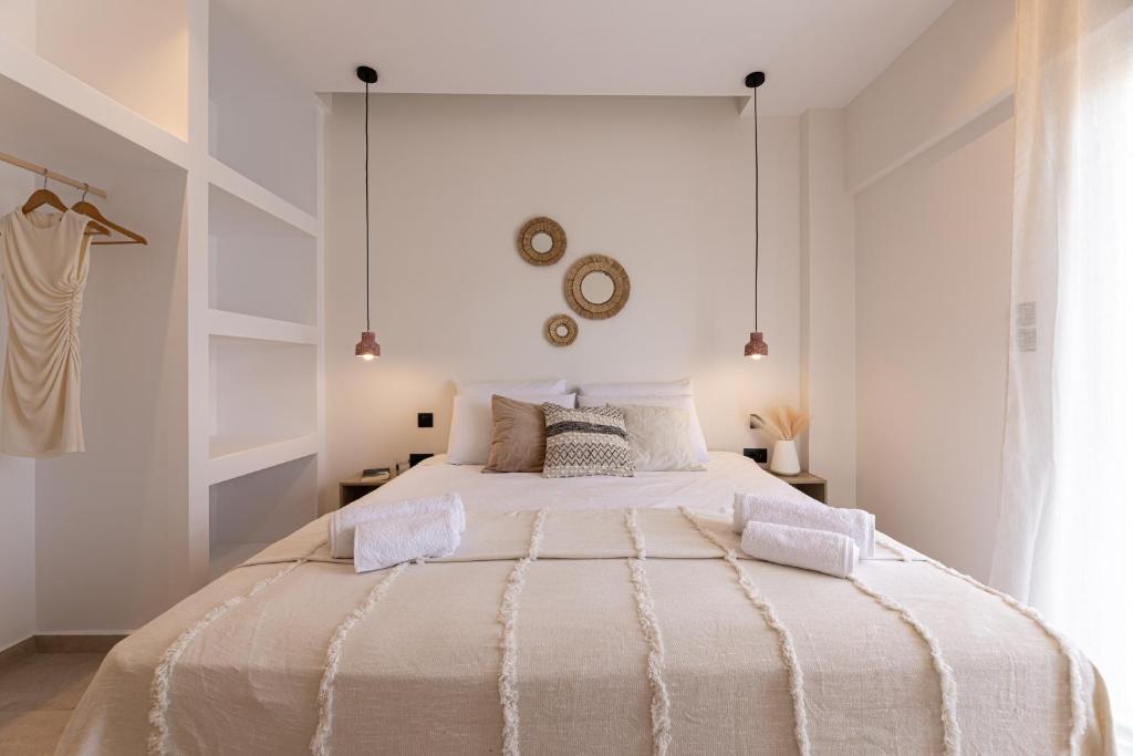 ein weißes Schlafzimmer mit einem großen Bett mit zwei Kissen in der Unterkunft Portogal Apartments in Argostoli