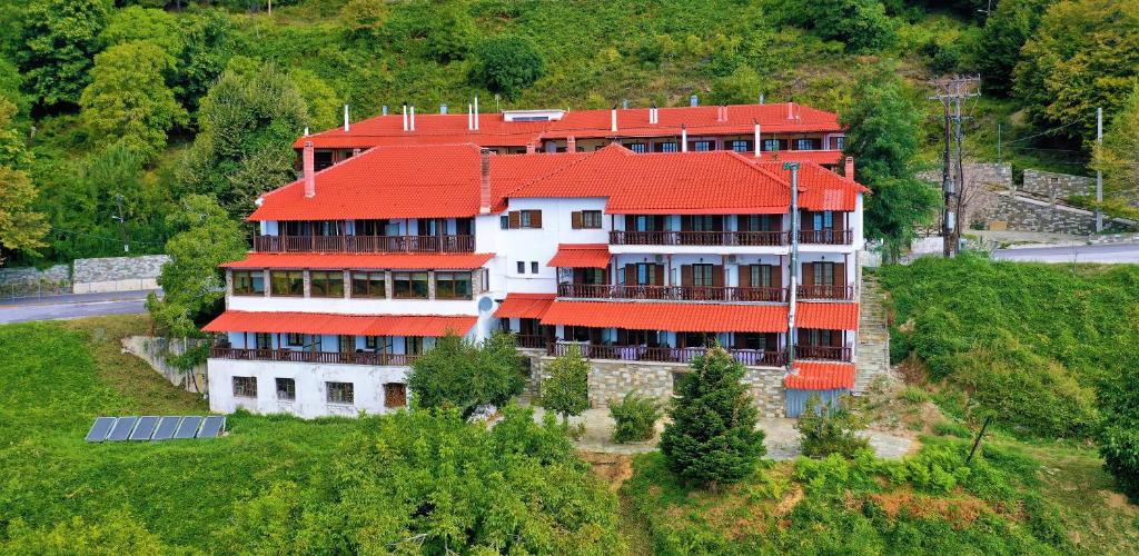 duży budynek z czerwonym dachem na wzgórzu w obiekcie Chania Hotel w mieście Chania