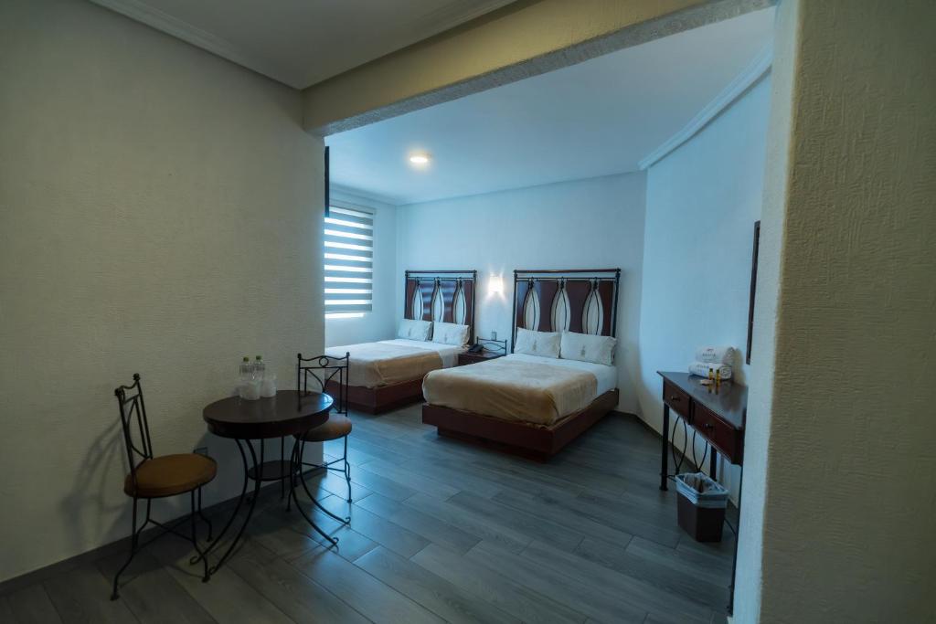 Postel nebo postele na pokoji v ubytování Hotel Alcazar - Guadalajara Centro Historico