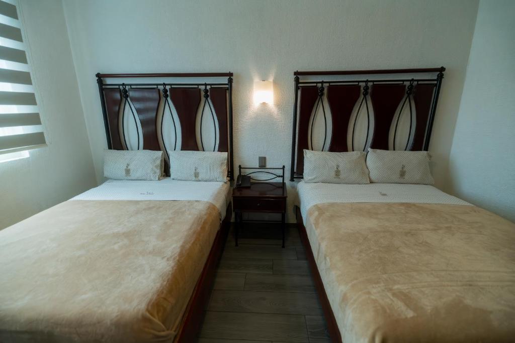 Postel nebo postele na pokoji v ubytování Hotel Alcazar - Guadalajara Centro Historico