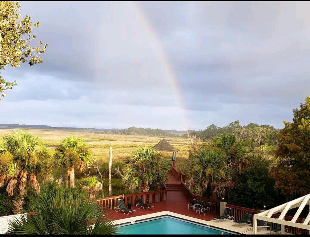 a rainbow over a house with a pool and palm trees at Mallard in Jacksonville