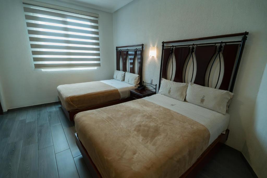 Postel nebo postele na pokoji v ubytování Hotel Alcazar - Guadalajara Centro Historico