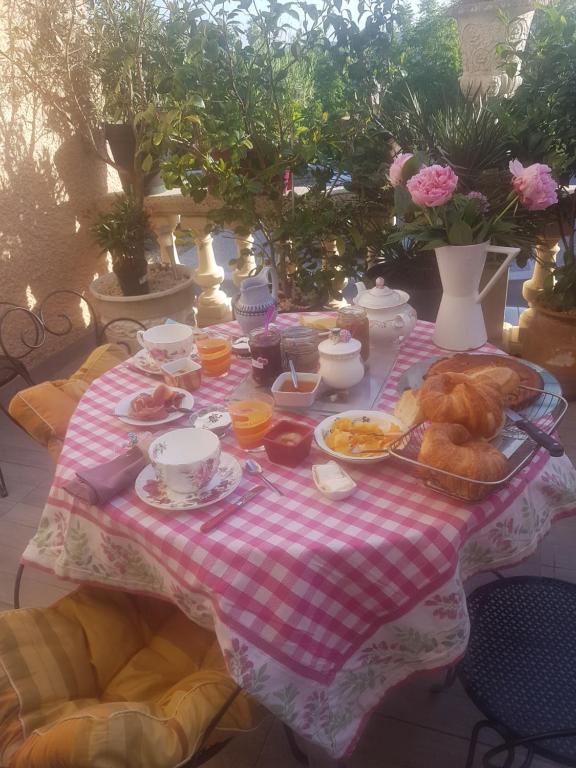a table with a table cloth with breakfast foods on it at Chambre d'hôtes chez Claude Bardou in Lacrouzette