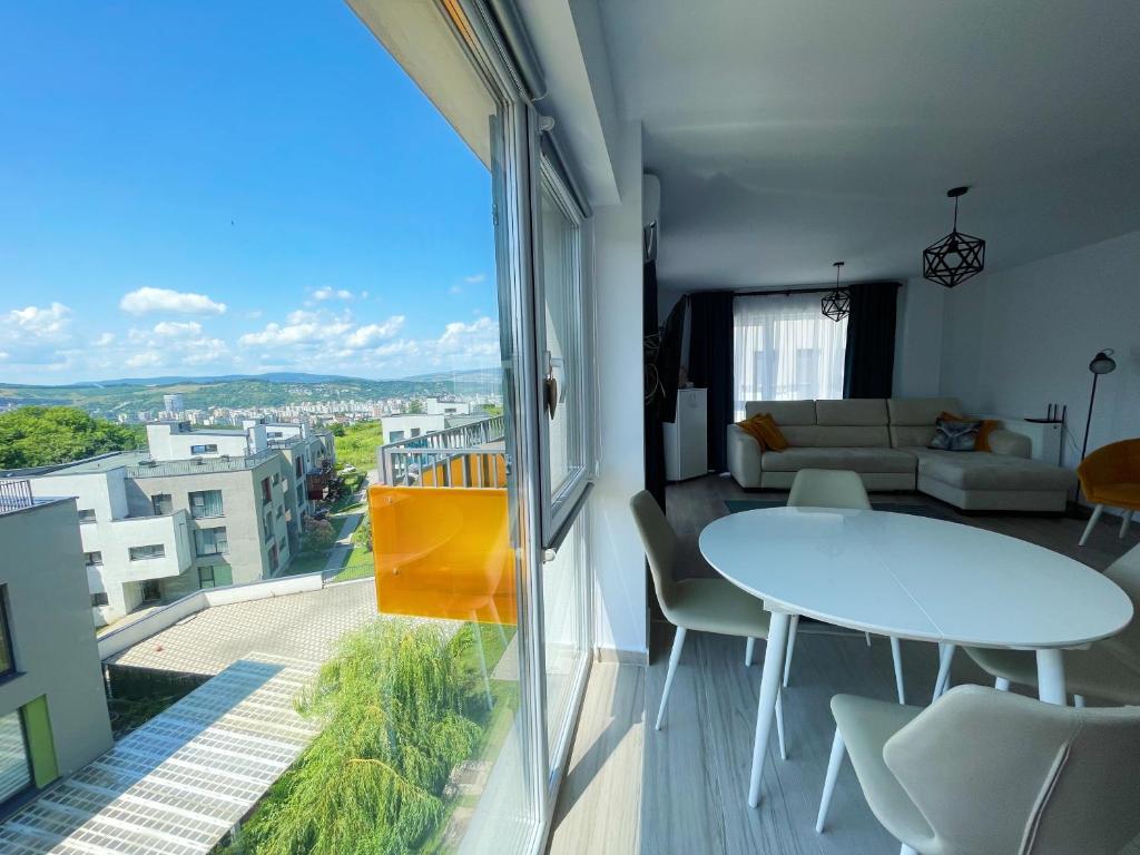 - un salon avec une table et une grande fenêtre dans l'établissement YamaLuxe Apartments - Citadel Residence, à Cluj-Napoca