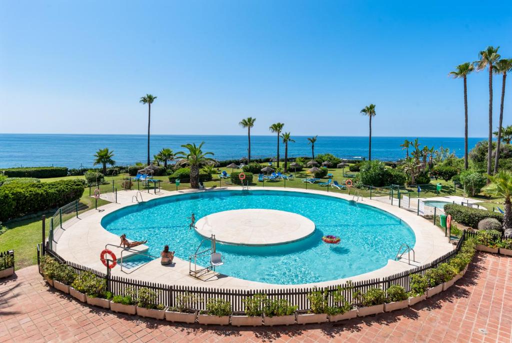 una piscina con el océano en el fondo en Miraflores Apartments by the Beach Costa Del Sol, en Mijas Costa