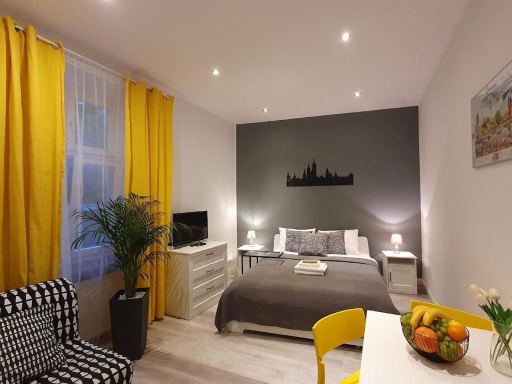 a bedroom with a bed and a table and chairs at L-2 Kraków Center Studio O&P ApartFamily in Kraków