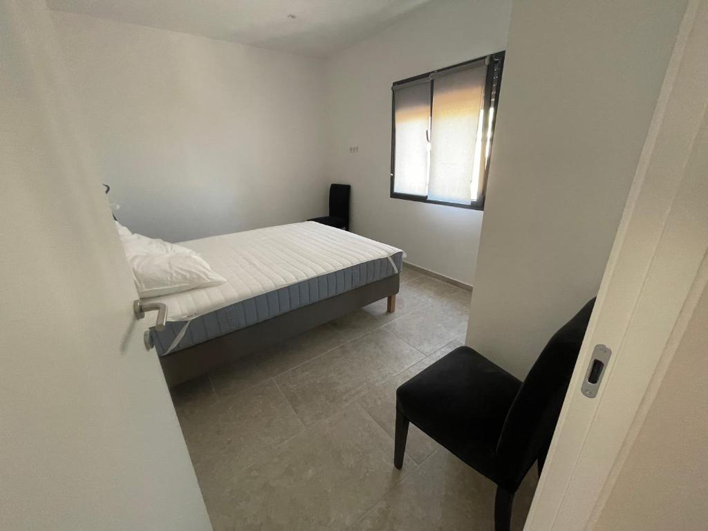 a small bedroom with a bed and a chair at Villa de standing in Calvi