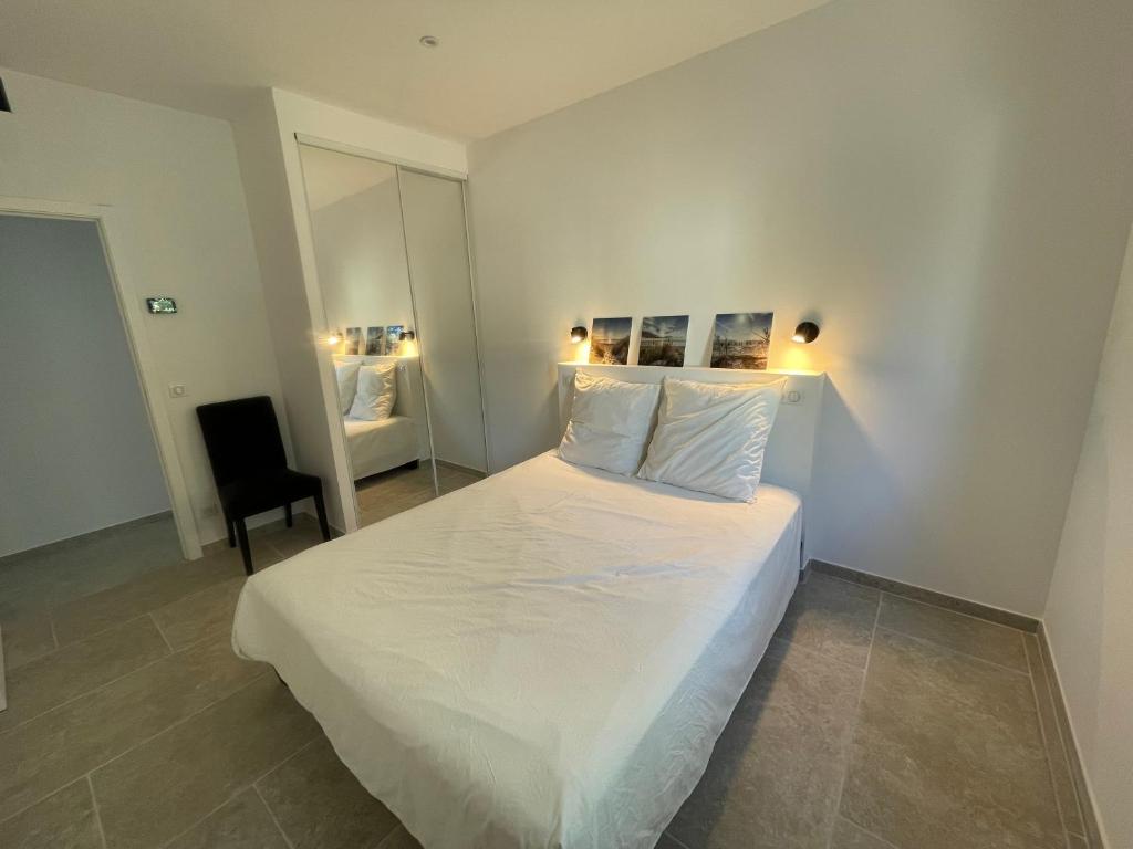 a bedroom with a large white bed and a chair at Villa de standing in Calvi