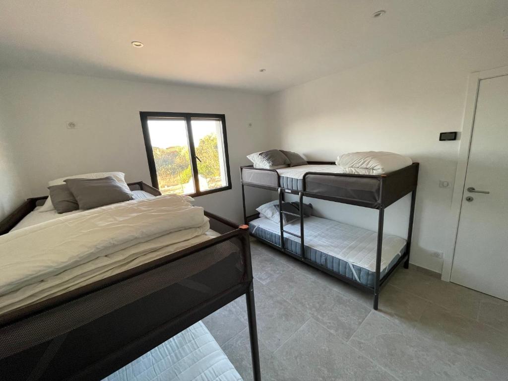 a bedroom with two bunk beds and a window at Villa de standing in Calvi