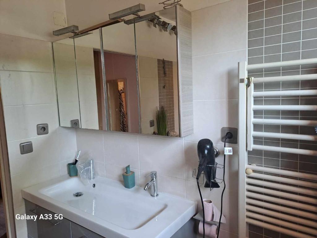 uma casa de banho com um lavatório e um espelho em chambre appartement terrasse em Fréjus