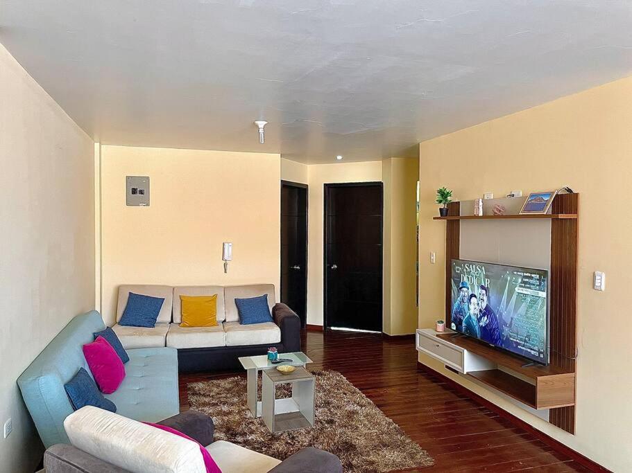 ein Wohnzimmer mit einem Sofa und einem Flachbild-TV in der Unterkunft Departamento independiente in Atuntaqui