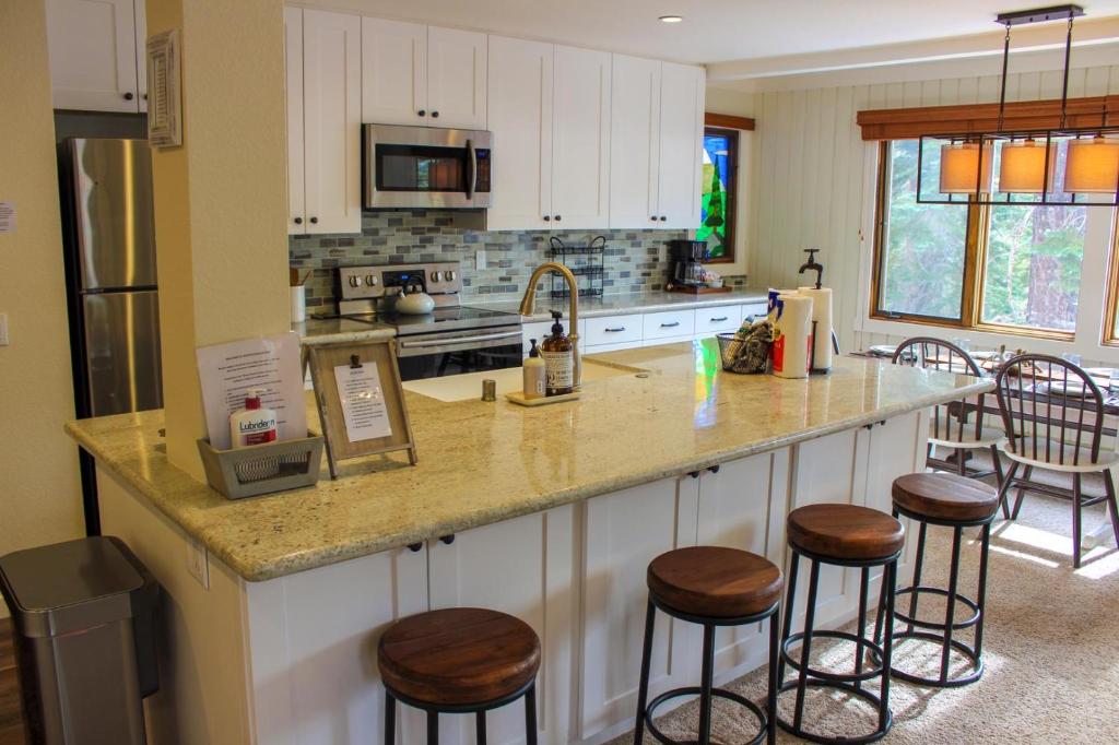 a kitchen with a large counter with stools in it at 418 - Bright Modern Comfy and Great Location in Mammoth Lakes