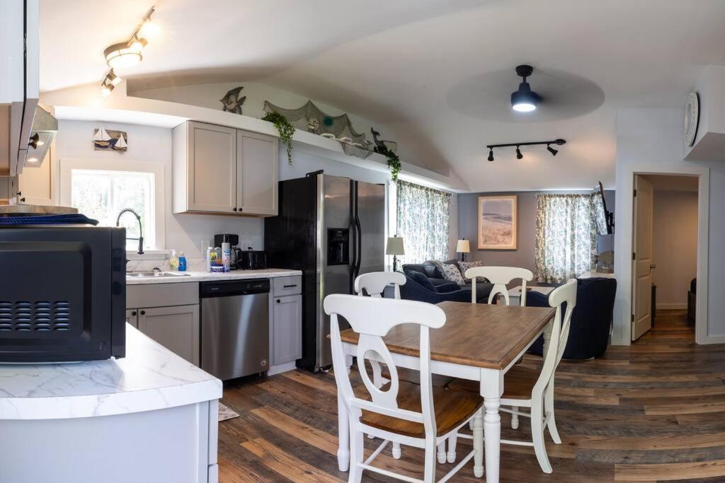 a kitchen and living room with a table and chairs at 3 Bedroom Pool PlayArea CampFire Cozy Apt in Bar Harbor