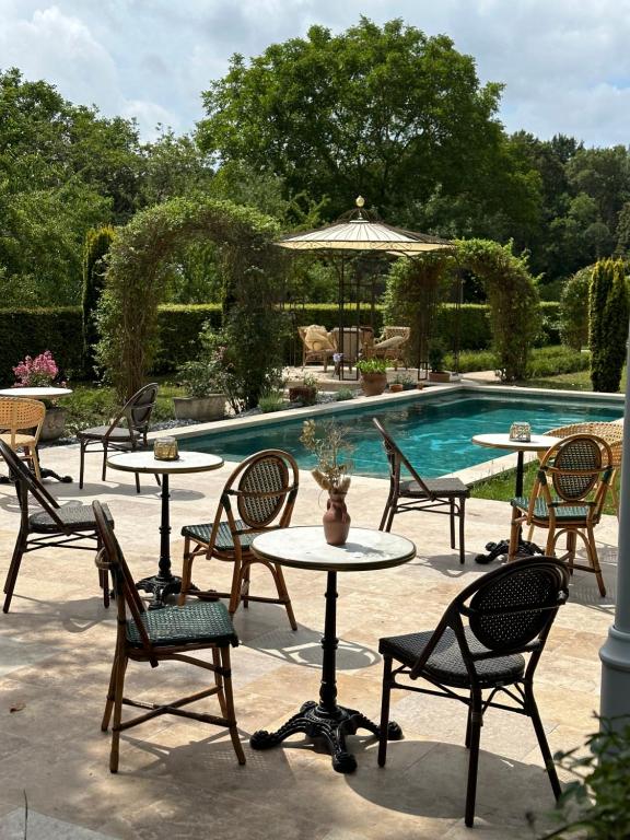 a group of tables and chairs next to a pool at LA GRANDE MAISON LGM in Lesches