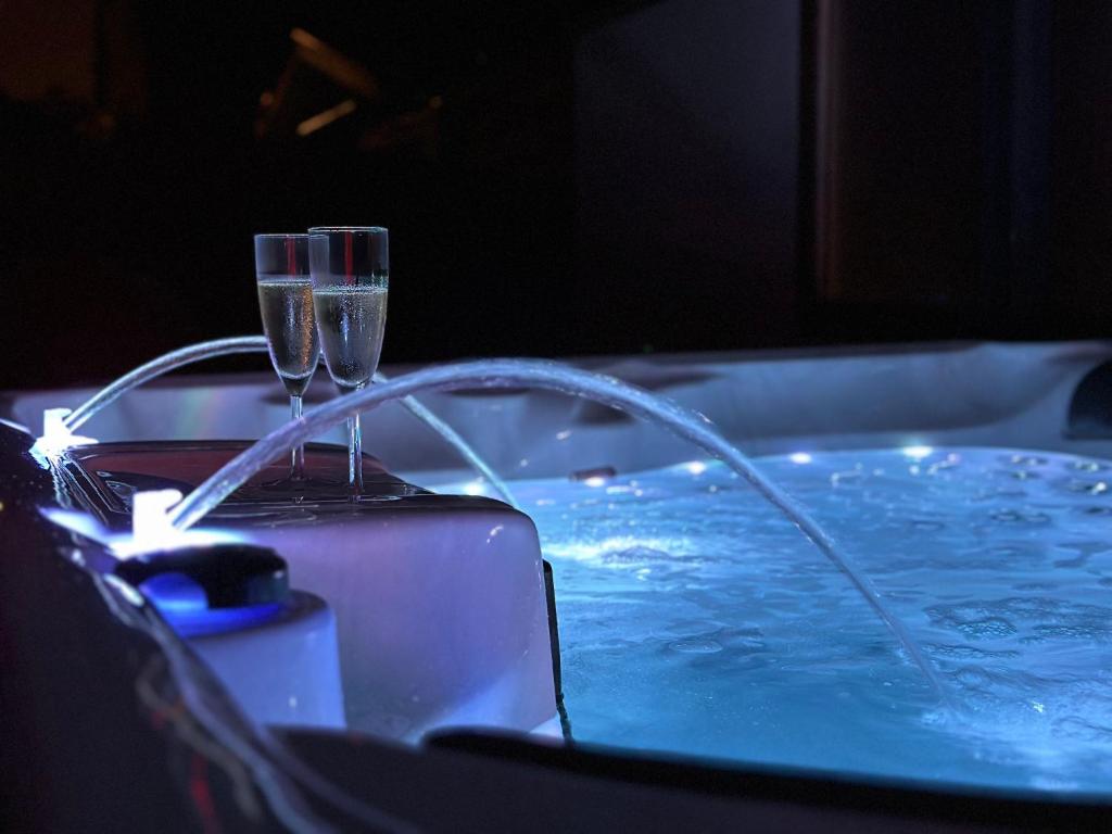 a bath tub with a glass of champagne next to a bath tub at l'Aphrodite in Huttenheim