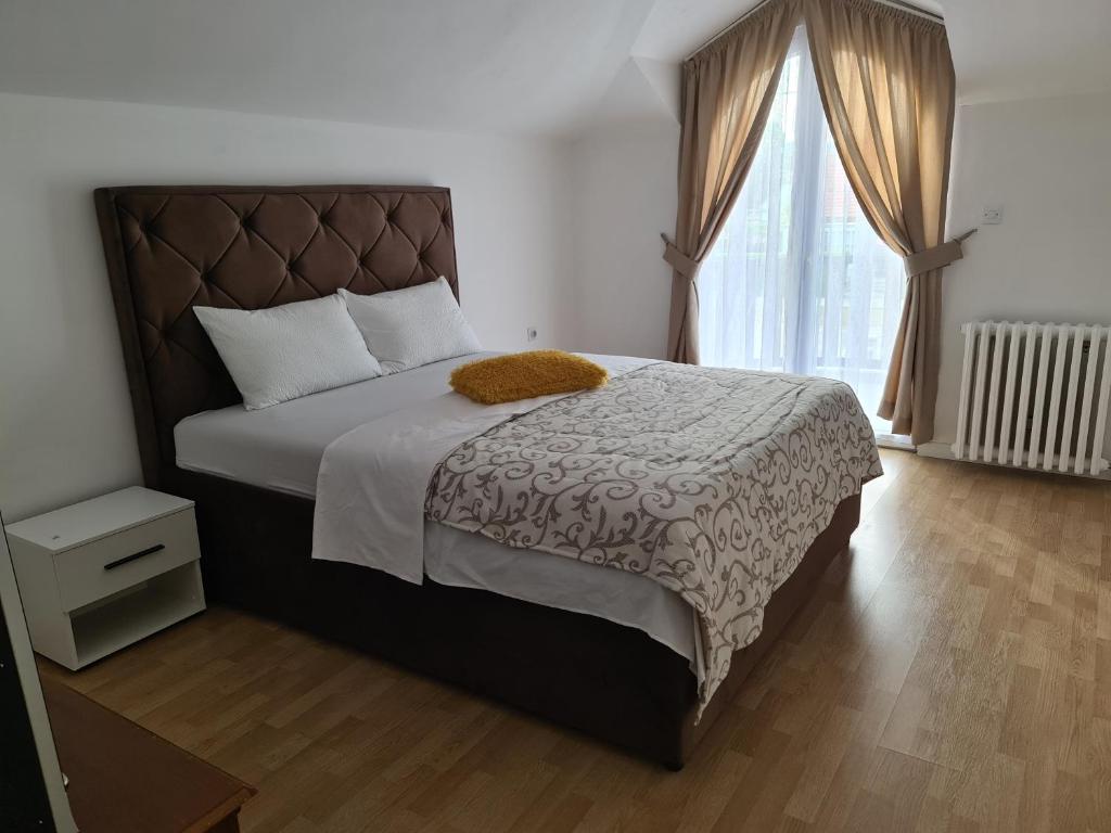 een slaapkamer met een bed en een groot raam bij JS APARTMAN in Nikšić