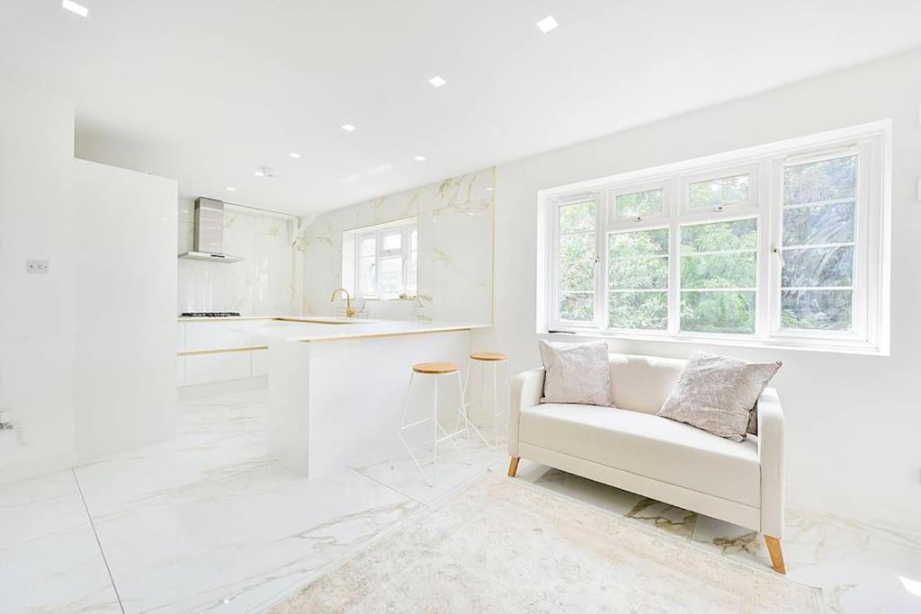 a white kitchen with a white couch and a window at PREMIUM Private Apartment minutes to Central London in London