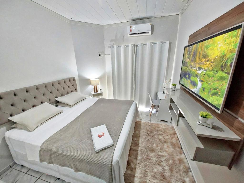 a bedroom with a large bed and a large television at Hospedagem Domiciliar em Lucas do Rio Verde in Lucas do Rio Verde