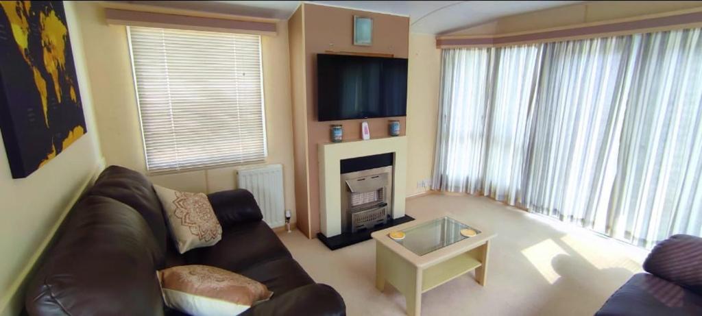 a living room with a couch and a fireplace at Snowdon Retreat in Llanrug