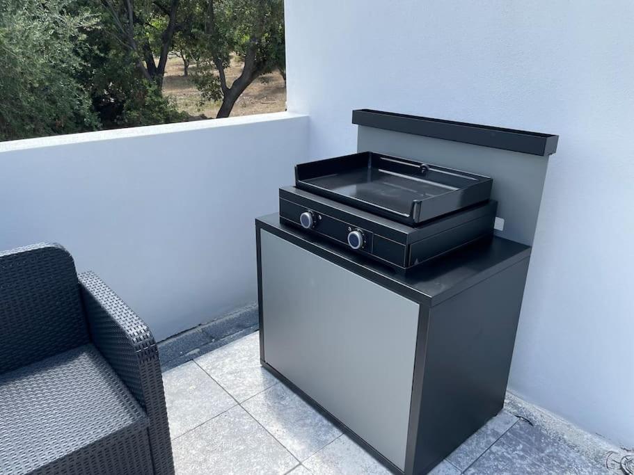 a barbecue grill on a stand next to a couch at Villa de standing in Calvi