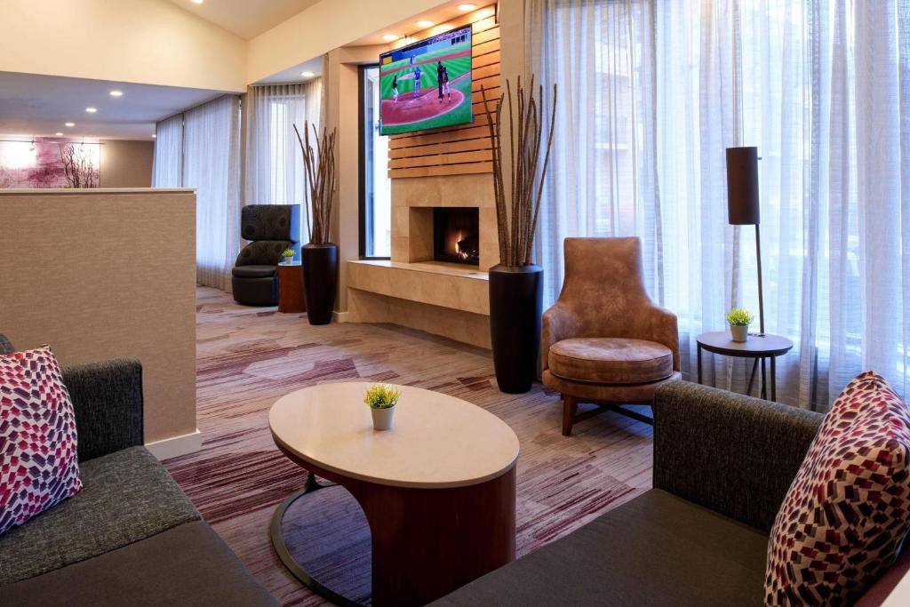 a hotel lobby with couches and a fireplace at Courtyard Detroit Metro Airport Romulus in Romulus