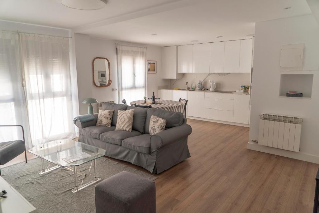 sala de estar con sofá y cocina en Preciosos apartamentos Riojaland en Lardero, en Lardero