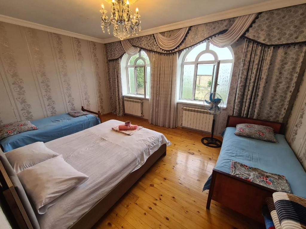 a bedroom with two beds and two windows at Green garden Zargan villa in Gabala