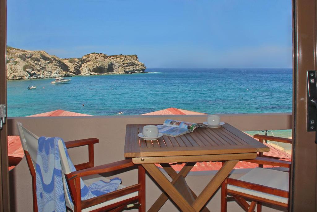 a table with two chairs and a view of the ocean at Lygaria Studios in Agia Pelagia