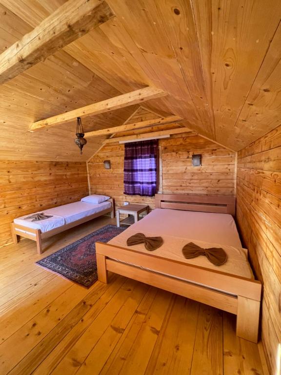 a room with two beds in a log cabin at Vikendice Moskva Uvac in Sjenica