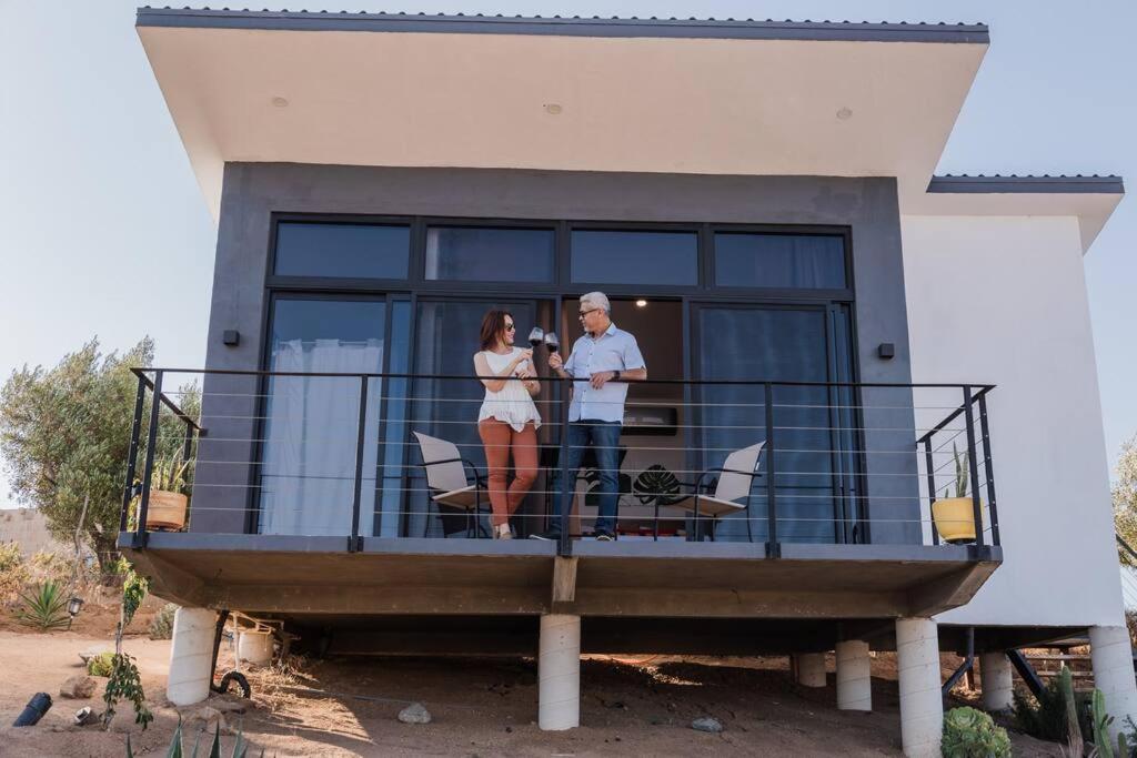 a man and woman standing on a balcony of a house at Starlight bungalow Queen 5 in Ensenada