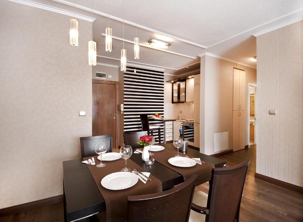 comedor con mesa y sillas y cocina en Apartments Carrera, en Sofía