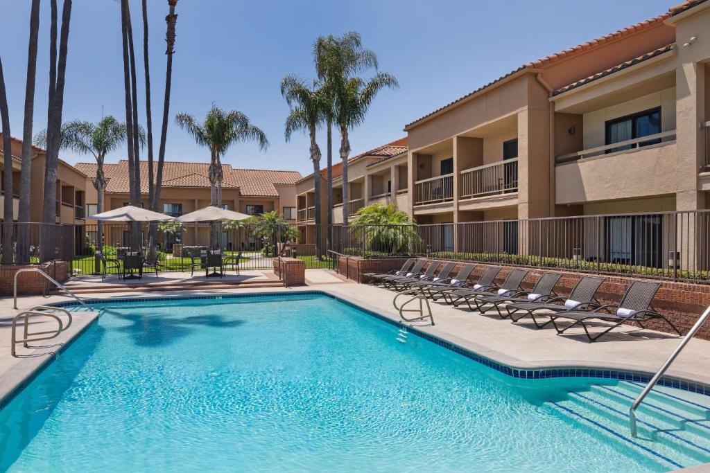 a swimming pool with lounge chairs and a resort at Courtyard Anaheim Buena Park in Buena Park