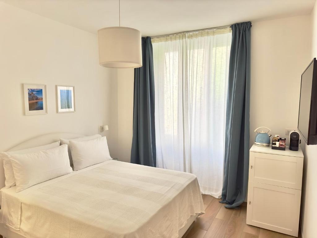 a bedroom with a white bed and a window at B&B Cellini in Santa Maria di Castellabate