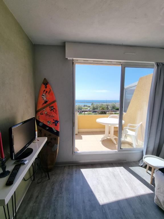 Habitación con escritorio, ordenador y ventana grande. en Sète vue mer linge fourni, en Sète