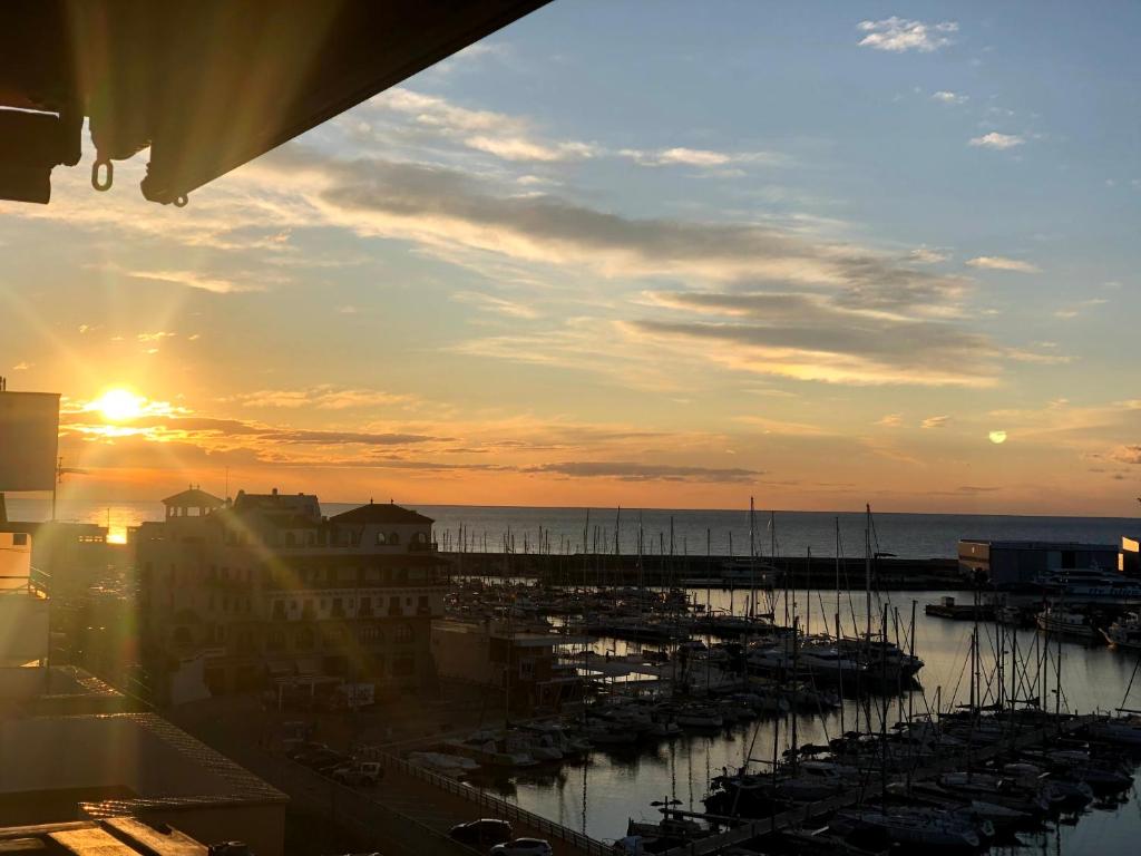 un coucher de soleil sur un port avec des bateaux dans l'eau dans l'établissement Apartamento playa, à Arenys de Mar