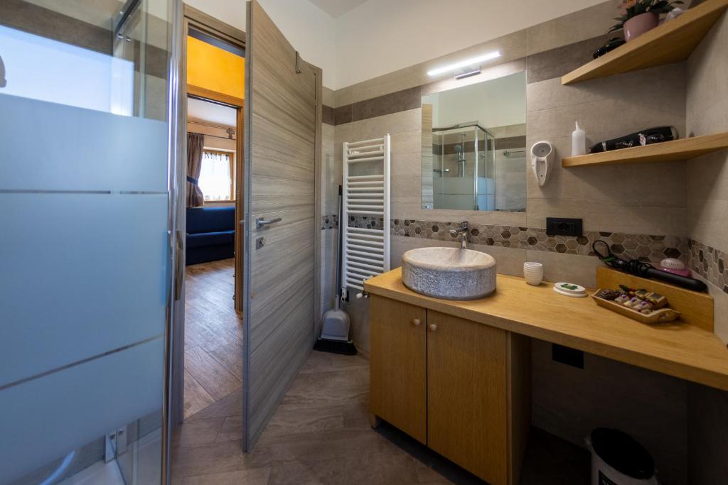 een badkamer met een wastafel en een spiegel bij Chalet Sunshine in Livigno