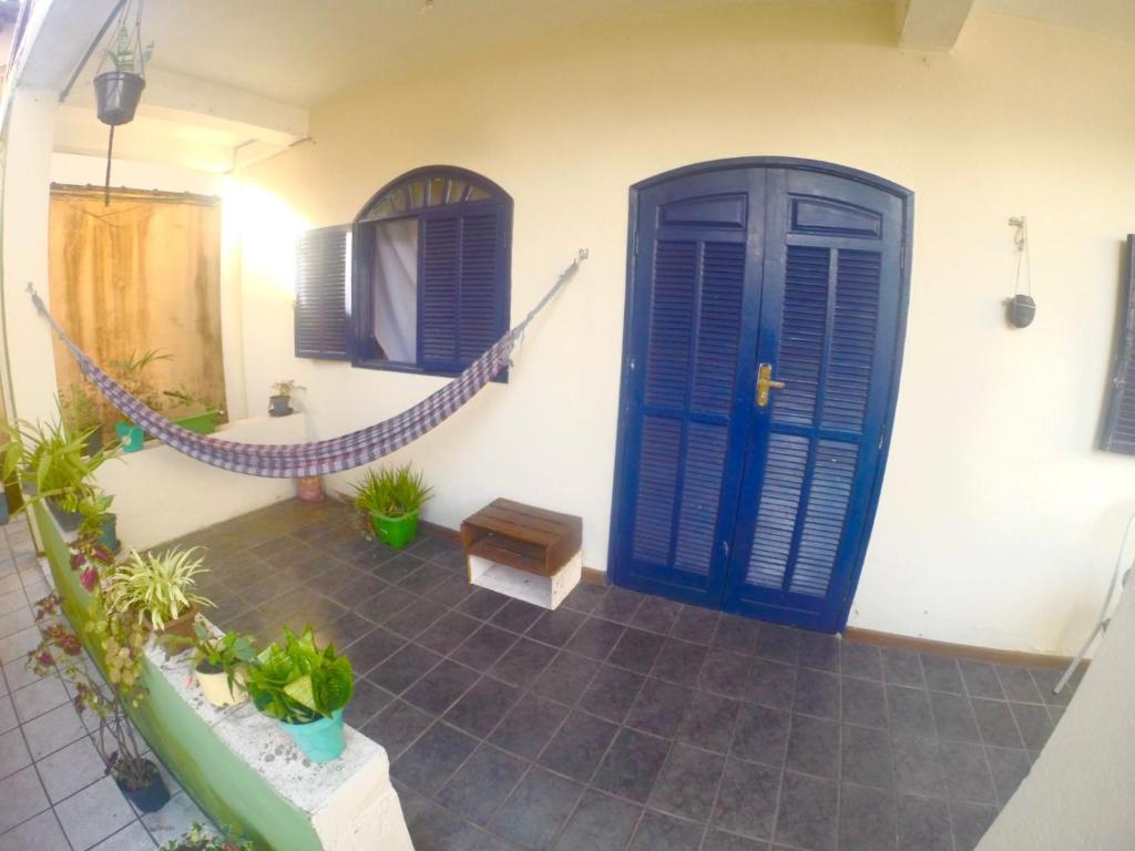 a room with blue doors and a hammock in a house at Casa Surya Paraty in Paraty