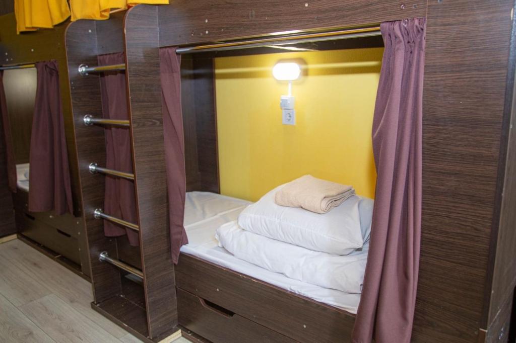 Cama pequeña en habitación con cortina en Sun City Hostel 4, en Kiev