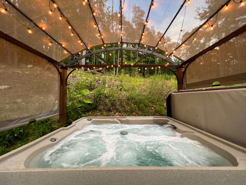 a hot tub in a tent with lights in it at Dreamy Couples Cabin in the Shenandoah Forrest in Luray
