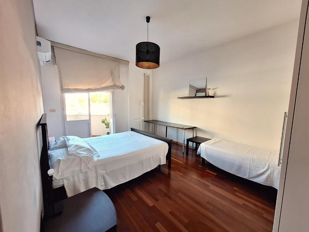 a bedroom with two beds and a table and a window at Appartamento 150 mq vicino al mare in Cattolica