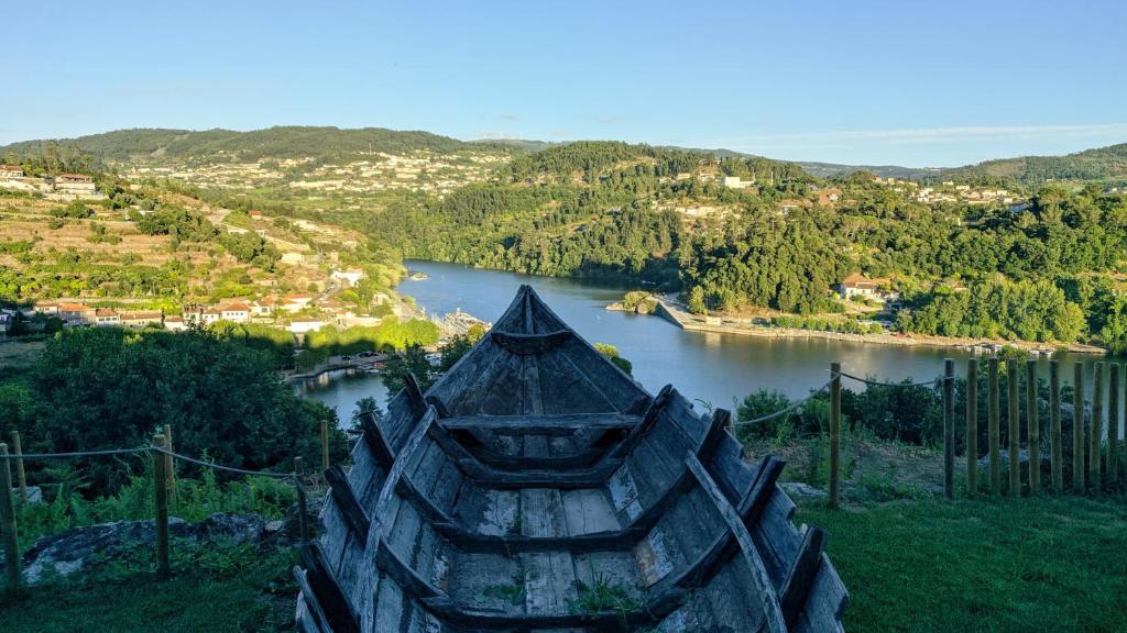 a view of a river with a boat in the foreground at Casa do Geraço - Douro Guest House in Várzea do Douro