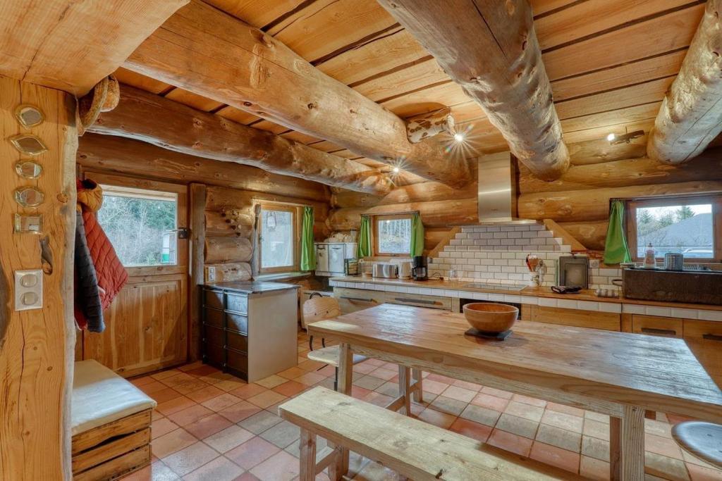 cocina con paredes de madera y mesa de madera en Chalet au bord d'un étang privé, Massif du Sancy, en Picherande