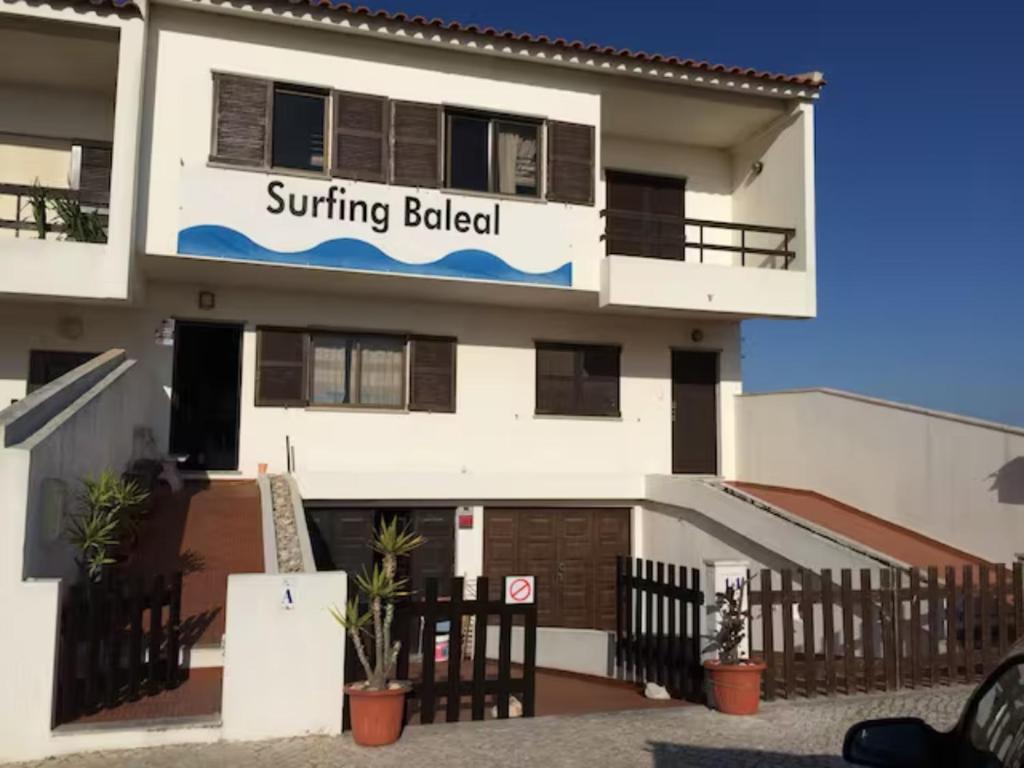 a building with a sign that reads surfing belicked at Beach House Surfing Baleal Peniche in Baleal