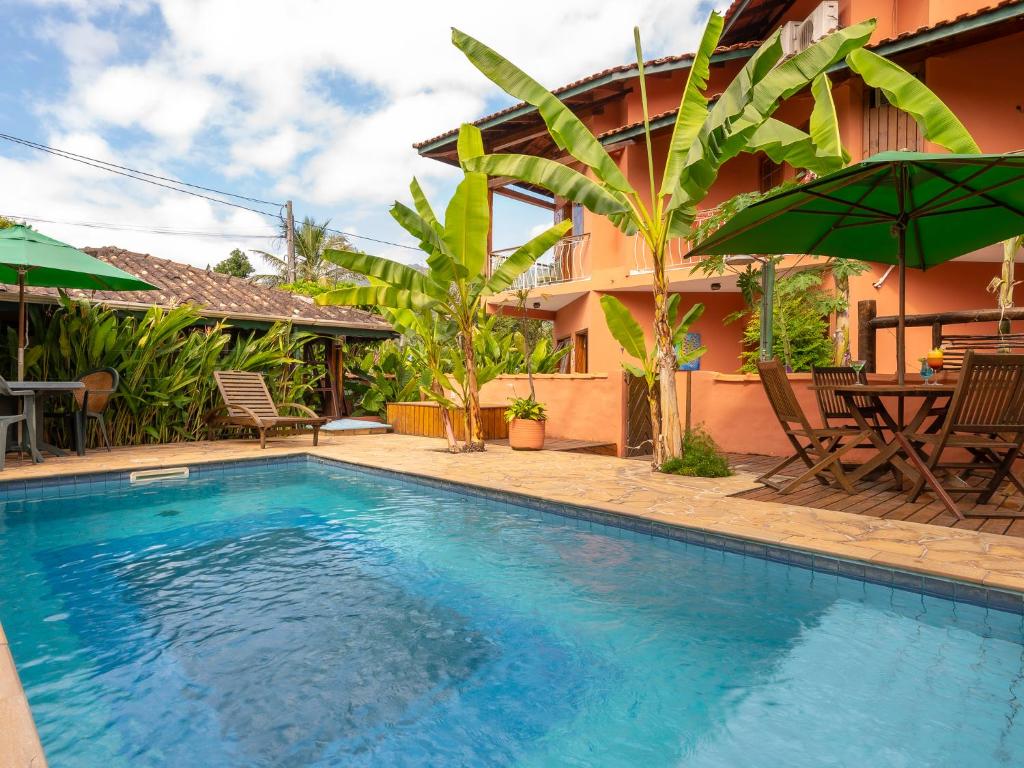 a swimming pool in front of a house at Pousada Atiaia in Ilhabela