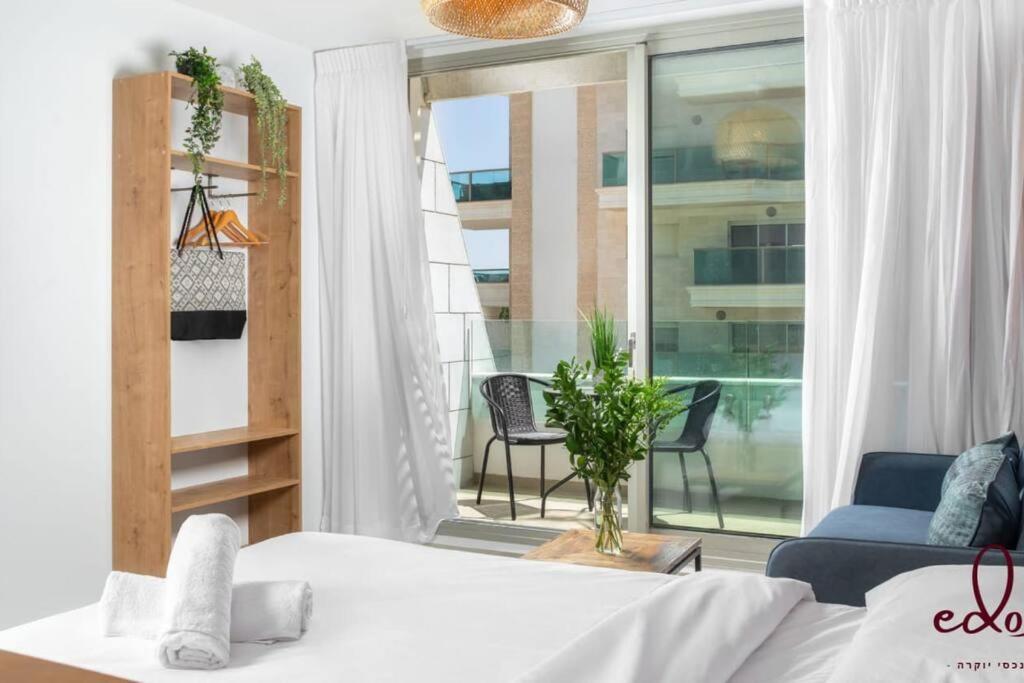 1 dormitorio con 1 cama y balcón con vistas. en Luxury living 100 meter from the beach - by Edom en Eilat