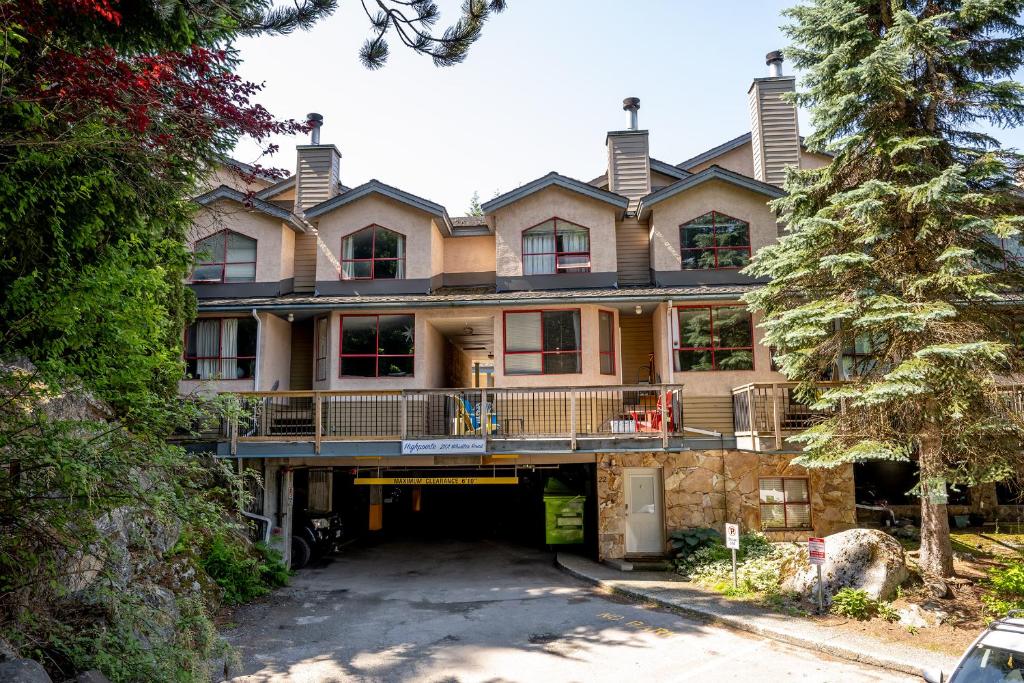 a large house with a driveway in front of it at Cozy Creekside Two-Storey Condo in Whistler